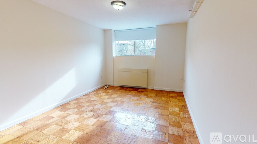 A room with a window and a radiator on the wall.