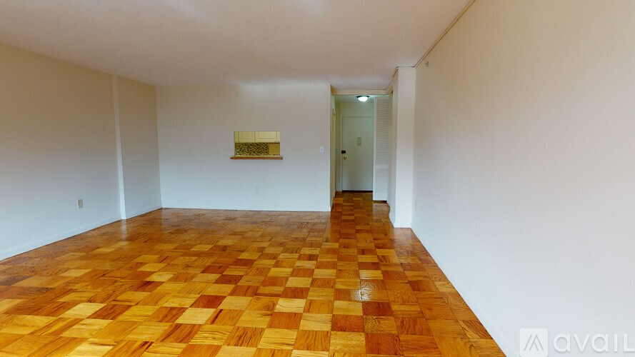 A room with a wooden floor and a door in the background.