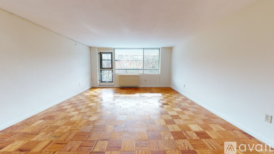 A room with wooden flooring and a window overlooking a cityscape.