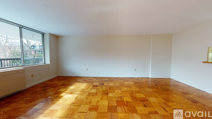 A room with wooden flooring and a large window.