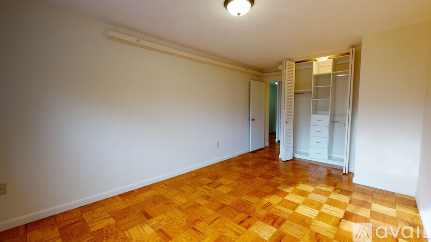 A room with wooden flooring and white walls.