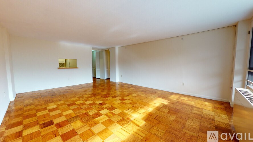 A room with a wooden floor and a white wall.