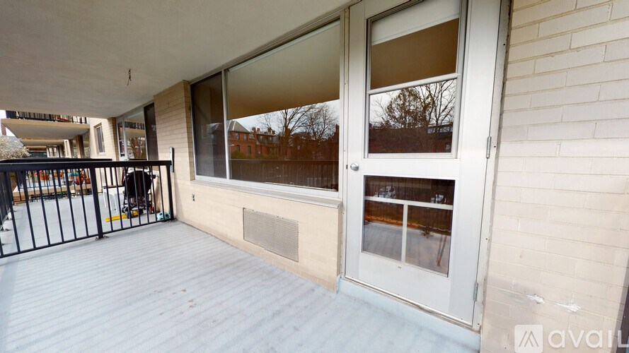 A balcony with a black railing and a white door.