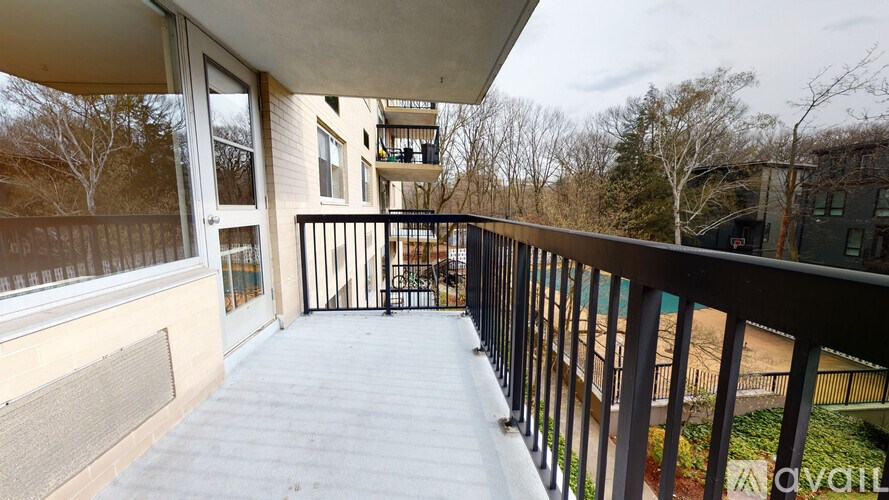 A balcony with a black railing and a white wall.