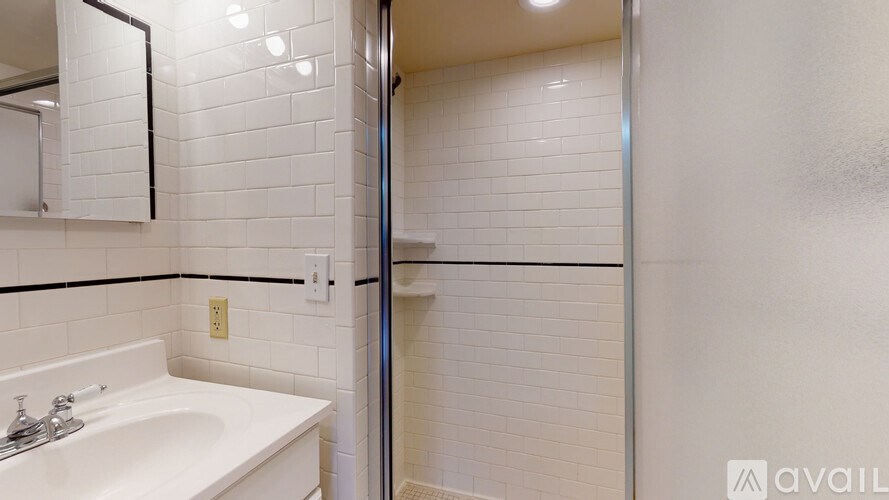 A white sink in a bathroom with a mirror above it.
