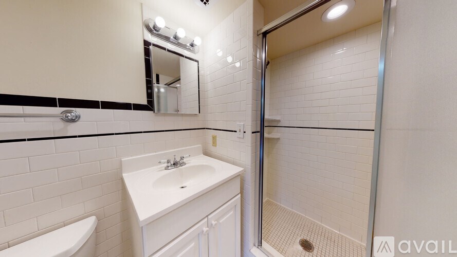 A white sink and toilet in a bathroom with a glass shower door.