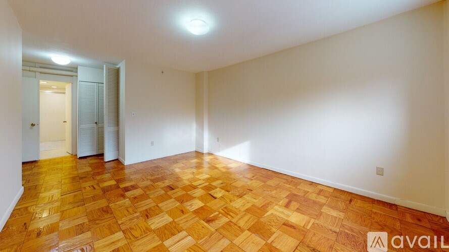 A room with wooden flooring and white walls.