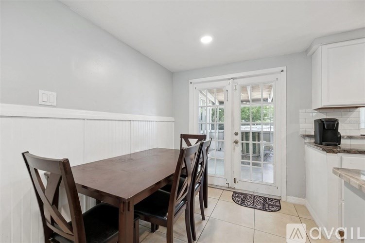 A dining room with a wooden table and chairs.