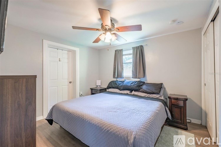 A bedroom with a bed, nightstand, and window.