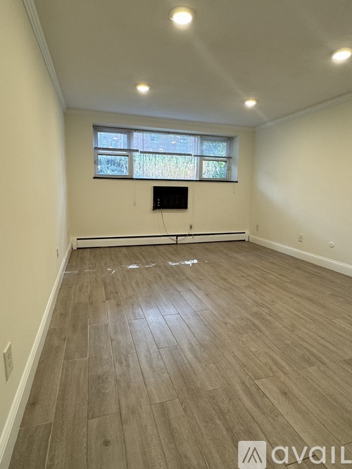 A room with wooden flooring and a window.