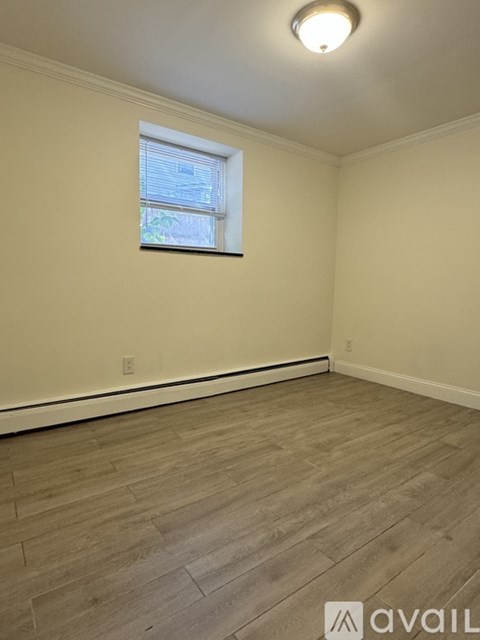 A room with a window and wooden flooring.