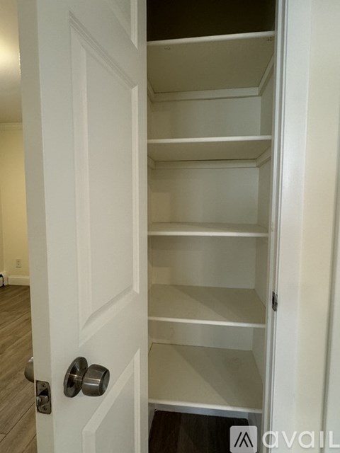A white door with a handle and a sign that says "AVAIL" on the bottom right.