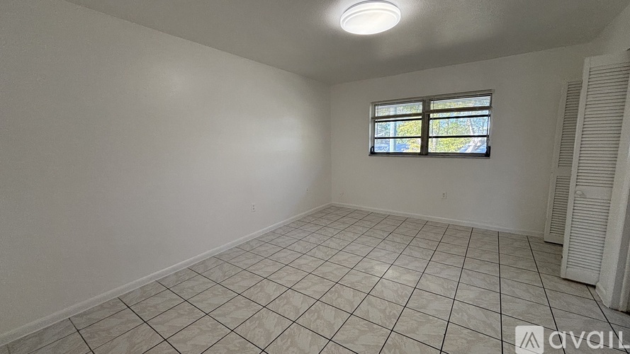 A room with a tiled floor and a window with a stained glass design.