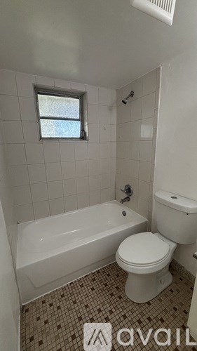 A white bathroom with a tub, toilet and sink.