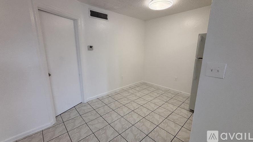 A room with a tiled floor and a door.