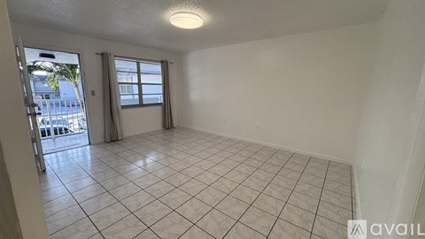 A room with tiled flooring and a sliding glass door leading to a balcony.
