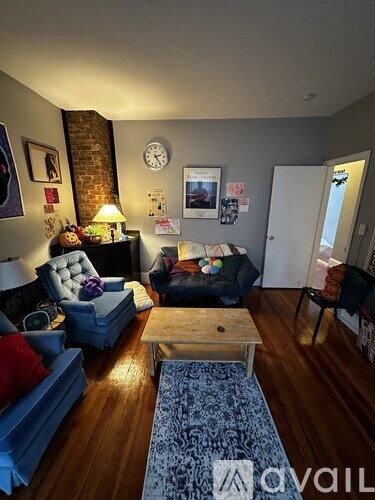 A living room with a brick wall and a couch.