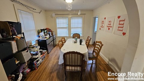 A dining room with a table and chairs and a sign on the wall that says "good food mood".