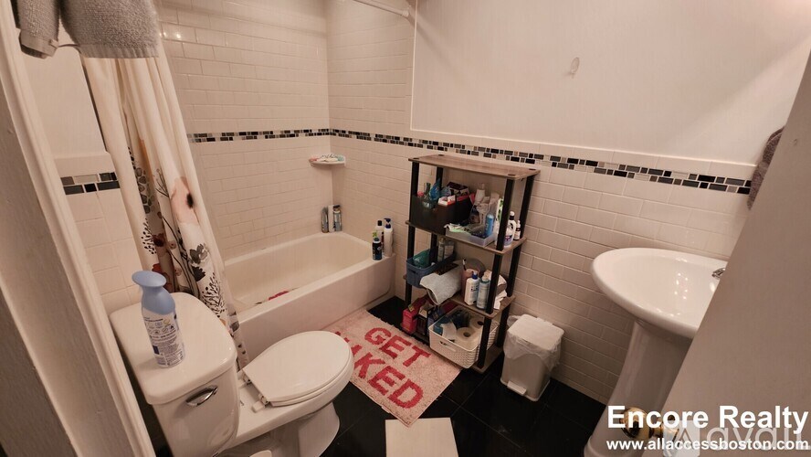 A bathroom with a white toilet, sink, and bathtub.