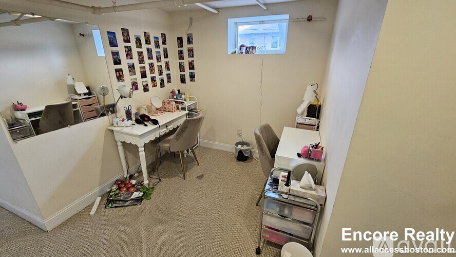 A room with a white table and chairs, a sink, and a window.