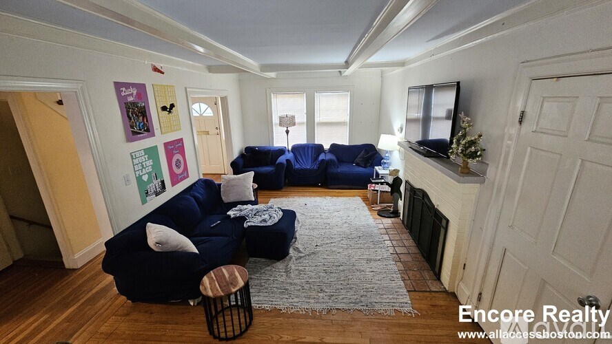 A living room with a blue couch and a grey rug.