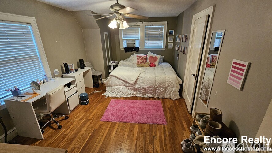 A bedroom with a bed, desk, and chair.