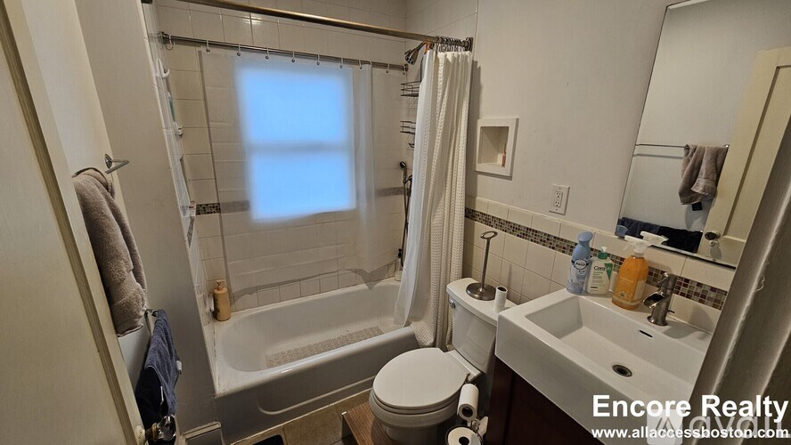 A bathroom with a toilet, sink, and bathtub.