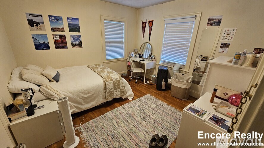 A bedroom with a bed, dresser, and a mirror.