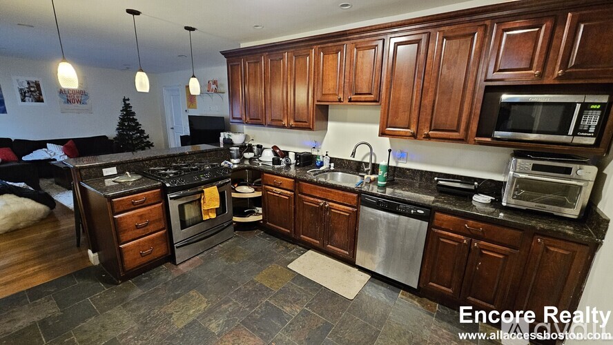 A kitchen with dark wood cabinets and a black stove top oven.