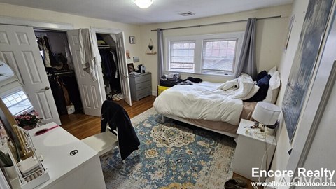 A bedroom with a bed, dresser, and wardrobe.