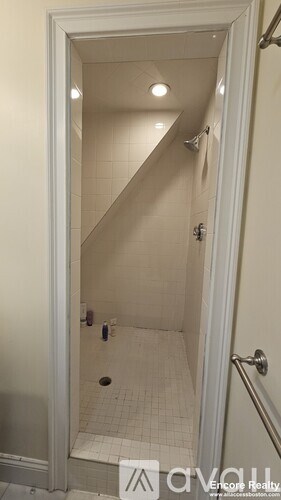 A white door with a glass shower stall in the bathroom.
