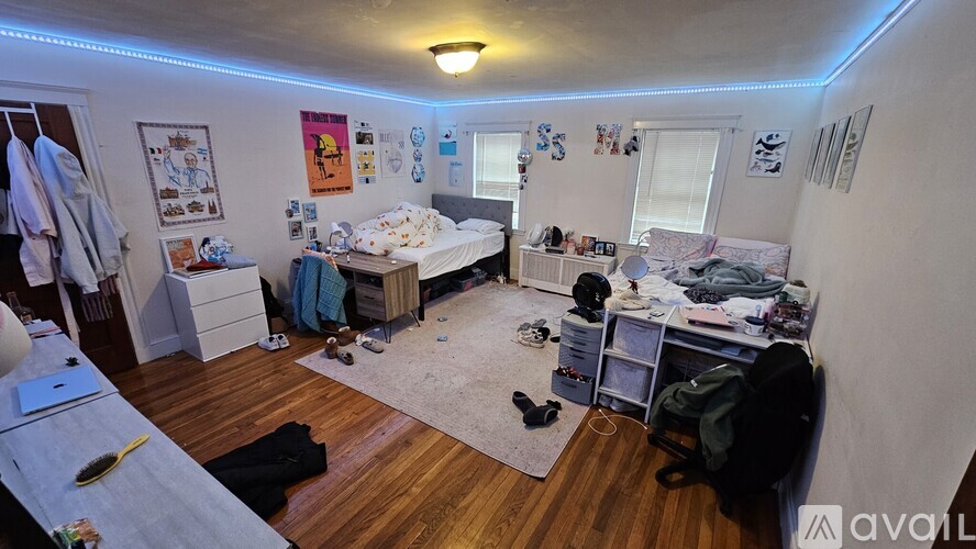 A bedroom with two beds, a desk, and a chair.