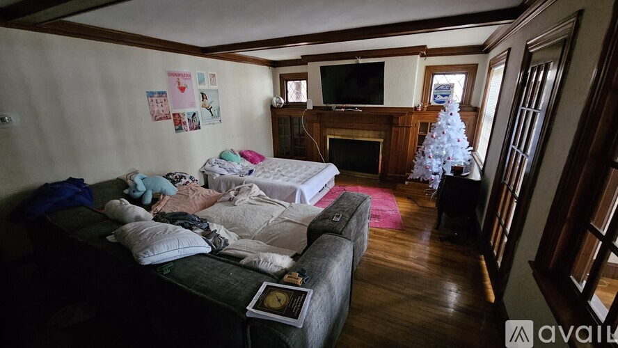 A messy bedroom with a couch and a Christmas tree.