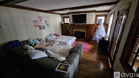 A messy bedroom with a couch and a Christmas tree.
