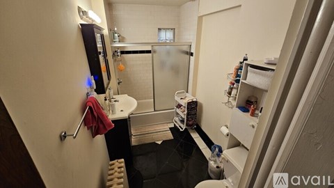 A small bathroom with a shower and a towel hanging on the door.