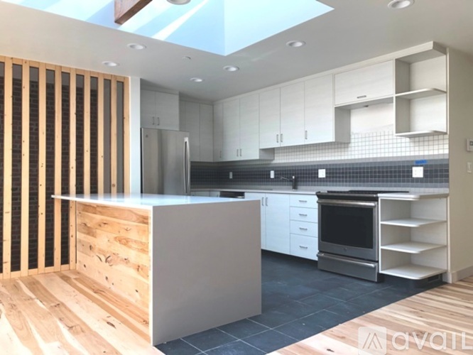 A modern kitchen with a skylight and wooden accents.