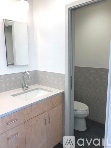 A bathroom with a sink, mirror, and toilet.