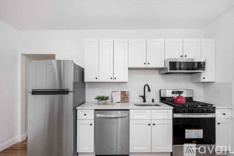 A kitchen with white cabinets and appliances.