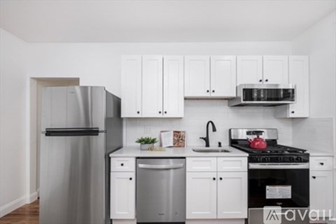 A kitchen with white cabinets and appliances.