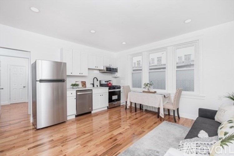 A modern kitchen with wooden floors and stainless steel appliances.