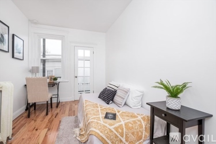 A bedroom with a bed, a desk, and a chair.