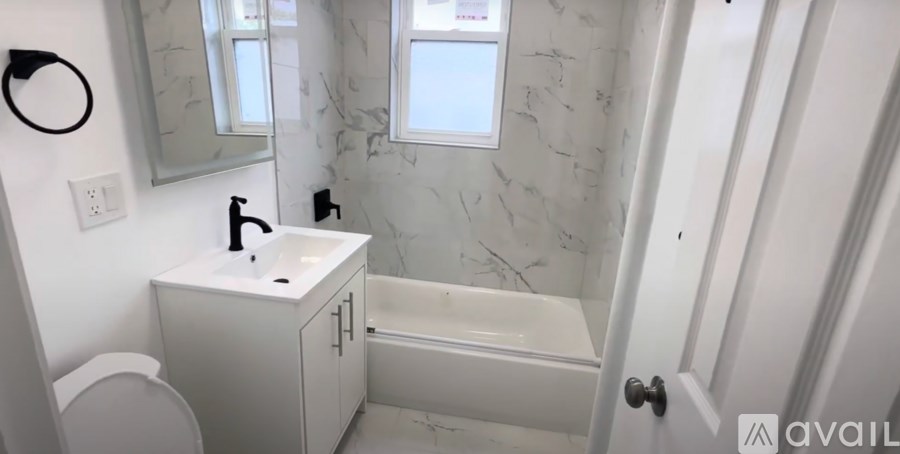 A bathroom with a white tub, sink, and toilet.