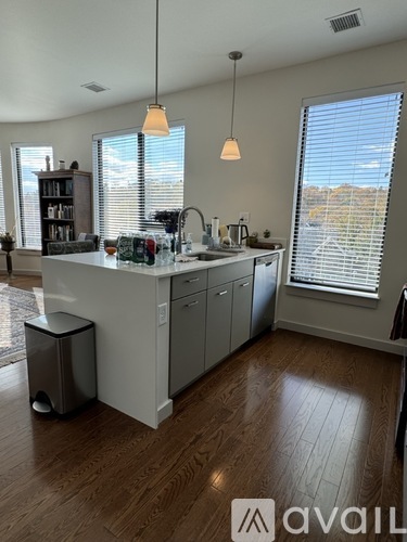 A kitchen with a large island and a window with blinds.