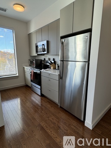 A kitchen with a refrigerator, microwave, and oven.