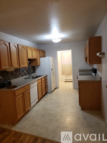 A kitchen with wooden cabinets and a white fridge.