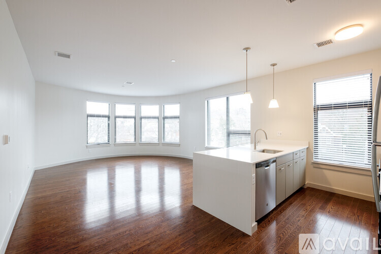 A kitchen with white appliances and wooden floors.