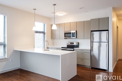 A kitchen with white cabinets and a stainless steel refrigerator.