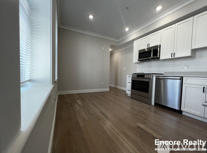 A kitchen with white cabinets and stainless steel appliances.