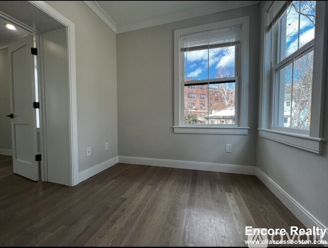 A room with a window showing a view of a building outside.