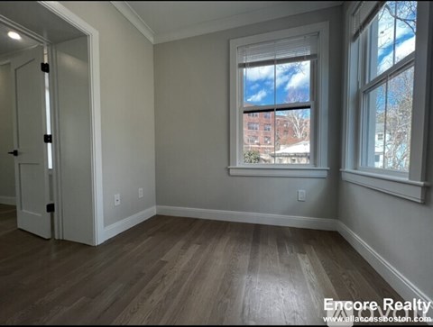 A room with a window showing a view of a building outside.